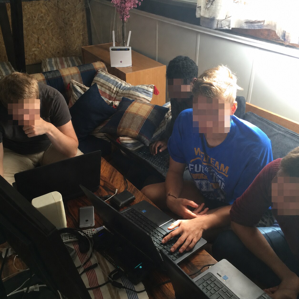 Four team members working together on laptops around a cottage table
